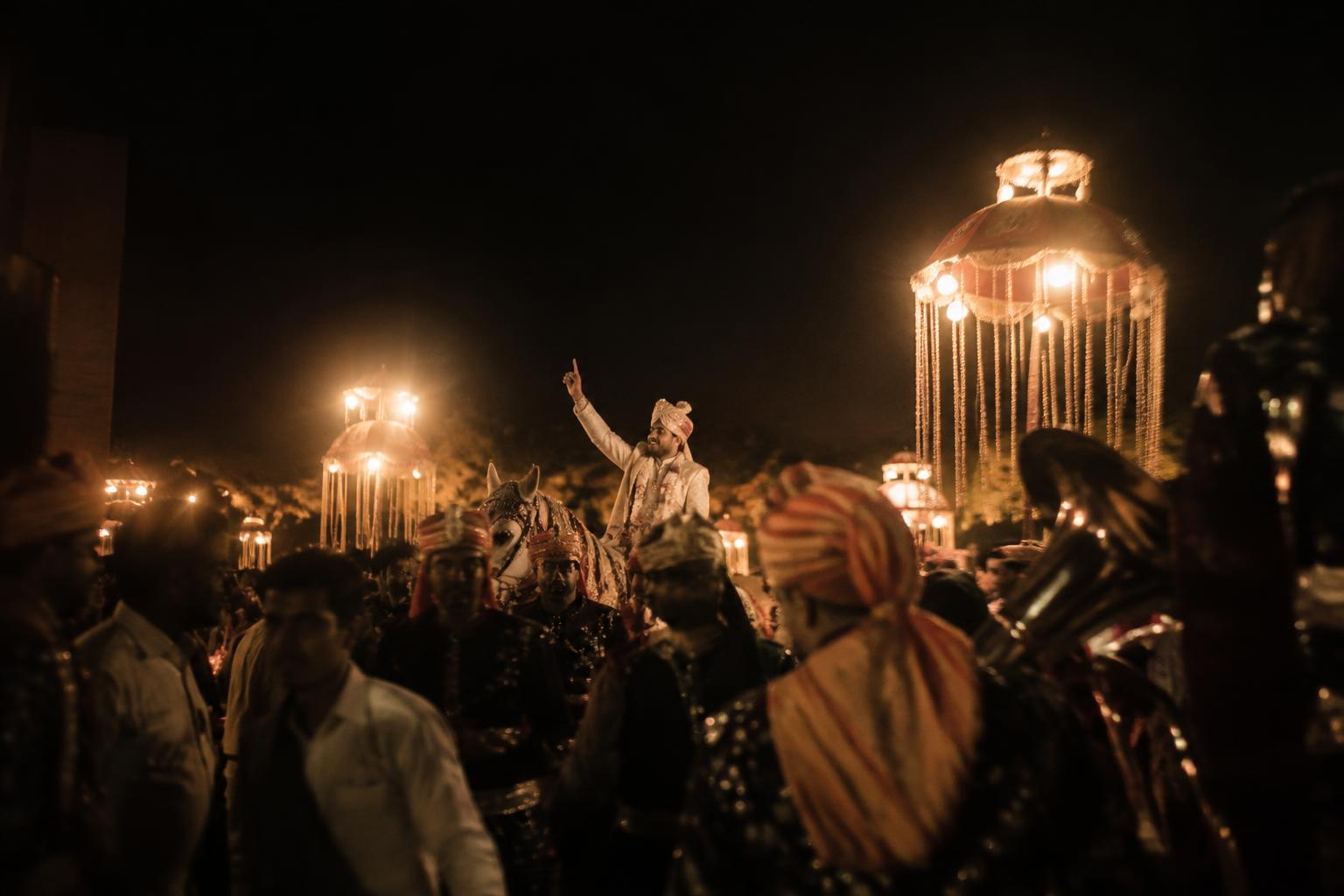 Baraat procession lit by warm lanterns at night